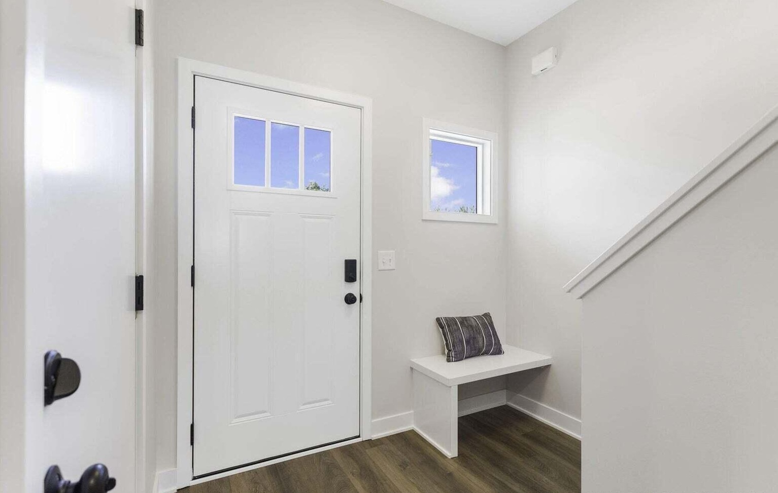 Bright townhome entry foyer with staircase and modern flooring