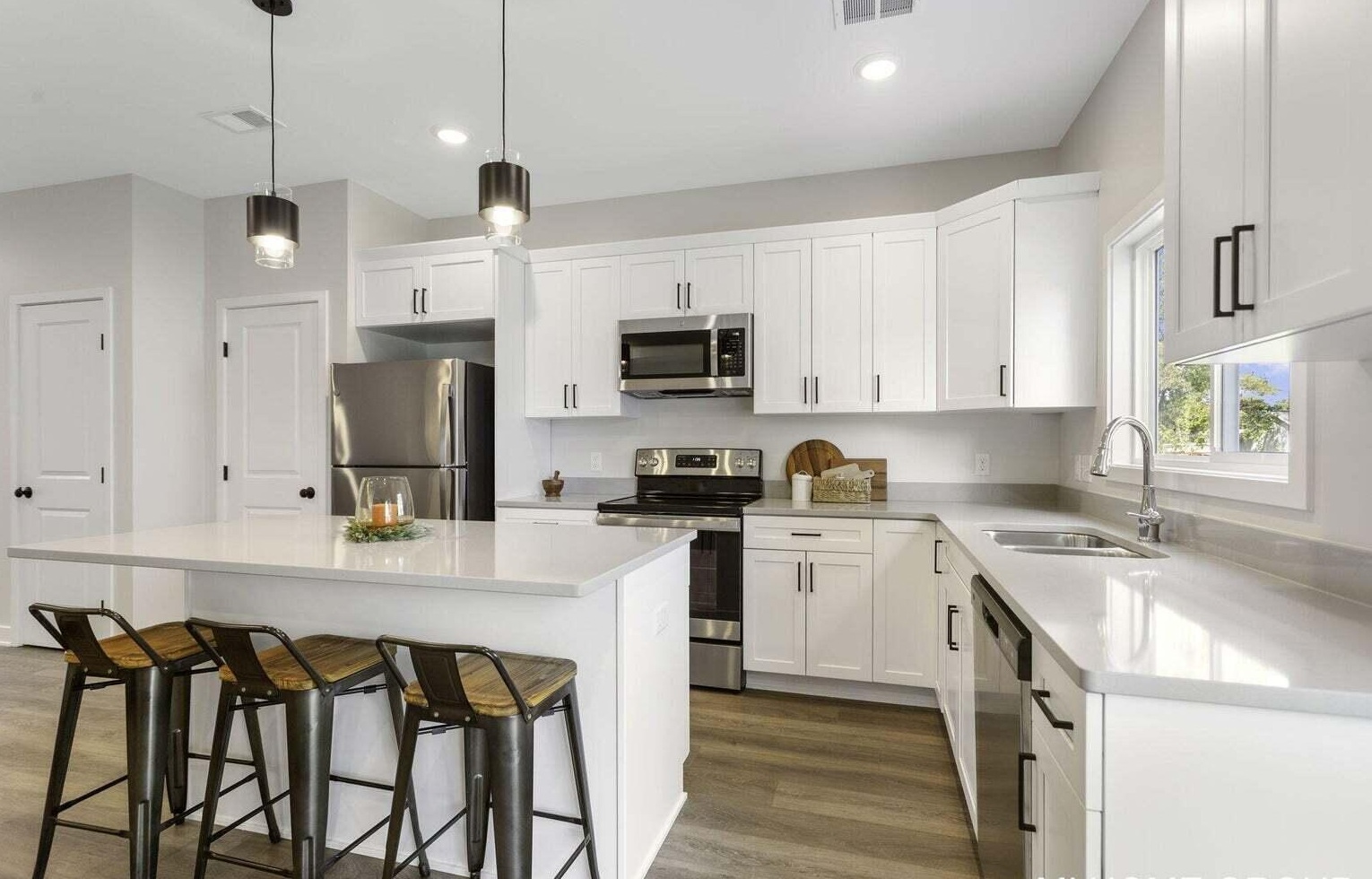 Open kitchen and dining area with island seating and large windows