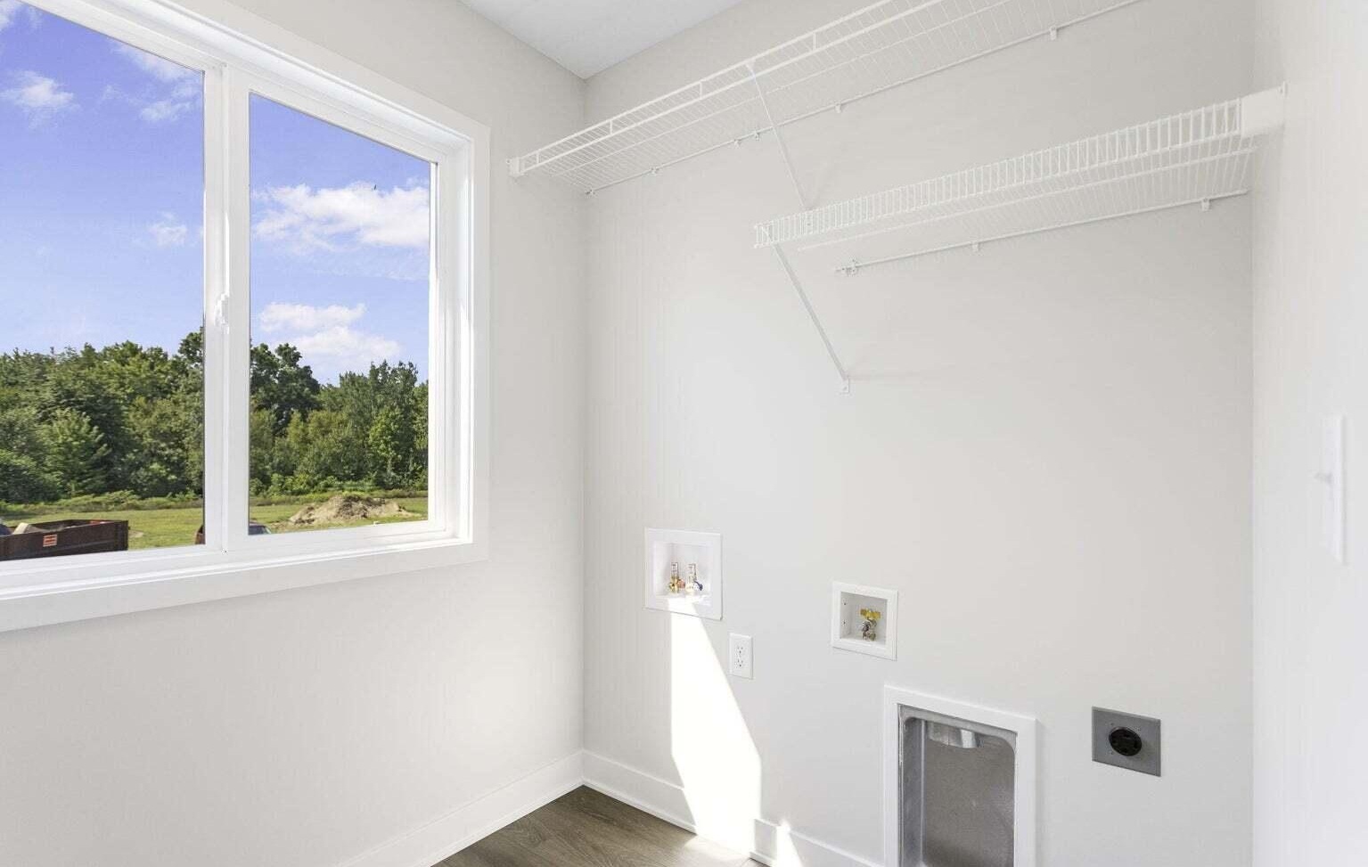 Bright laundry room with storage shelving and large window