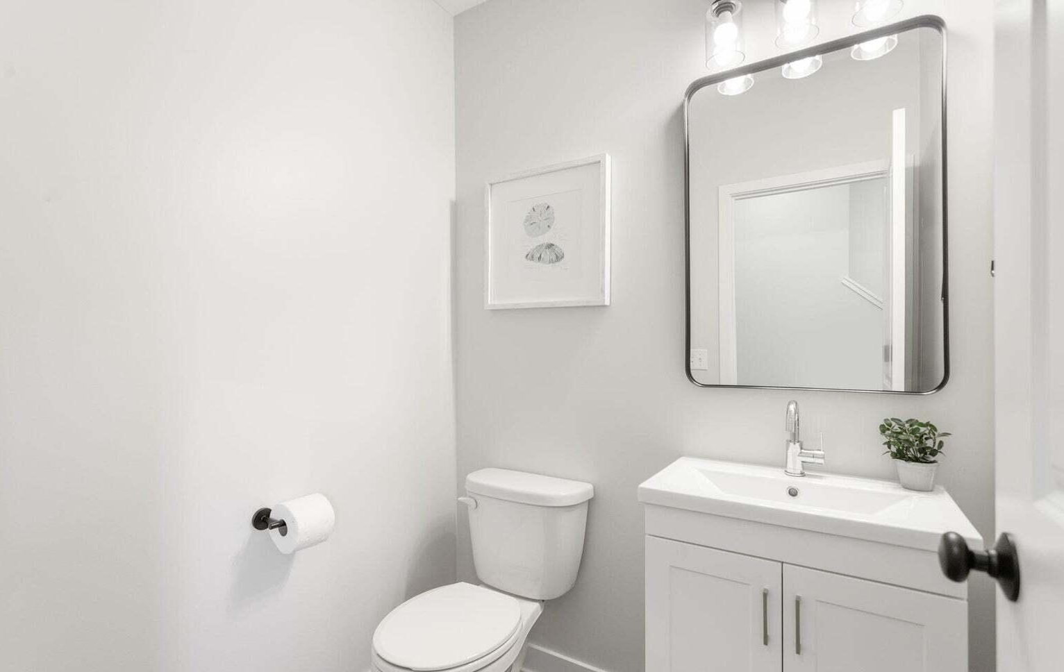 Stylish powder room with white vanity and modern rectangular mirror