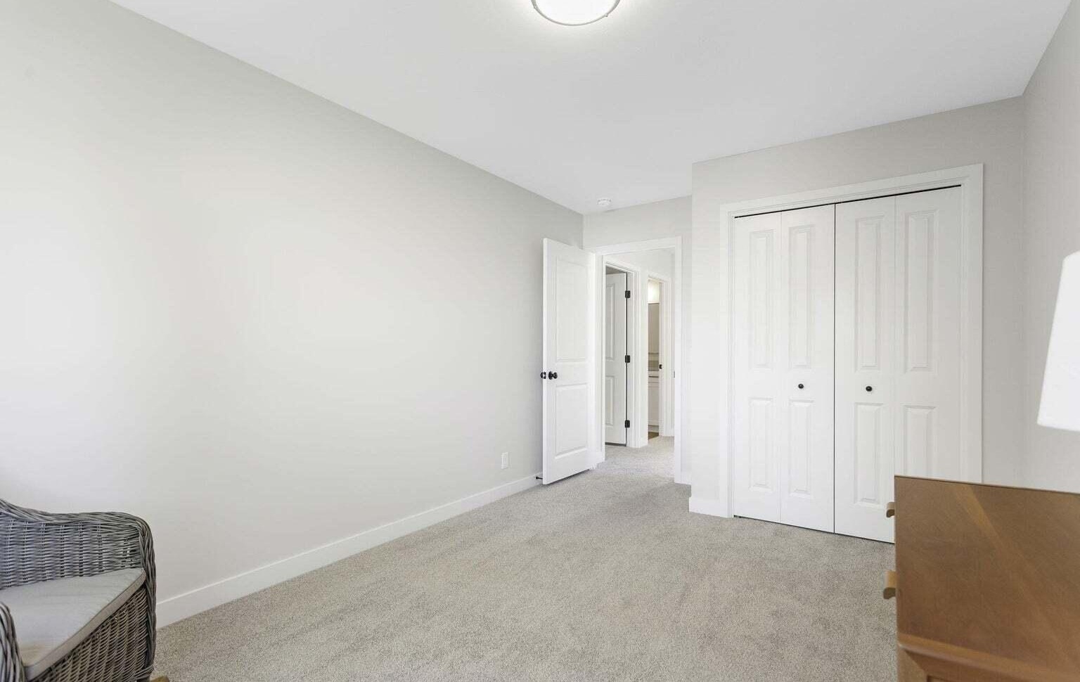 Spacious secondary bedroom with double-door closet and neutral finishes