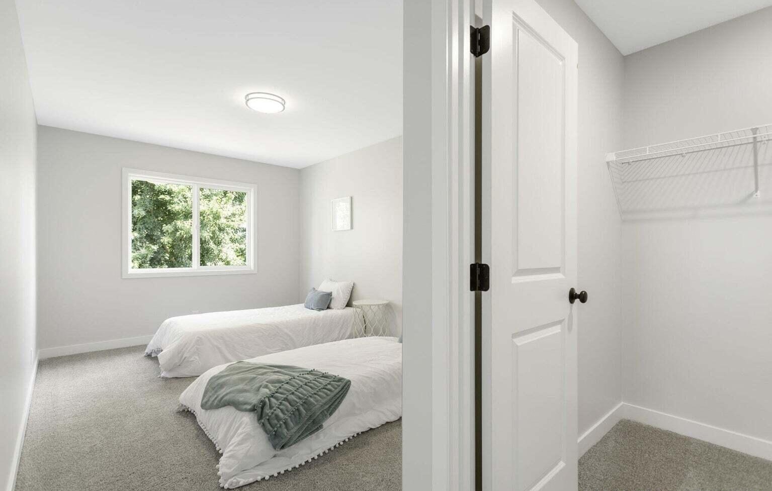 Bright secondary bedroom with large window in a Signature Estates townhome